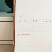 Planner open on a desk with handwritten 'Holiday Email Marketing Series' note.