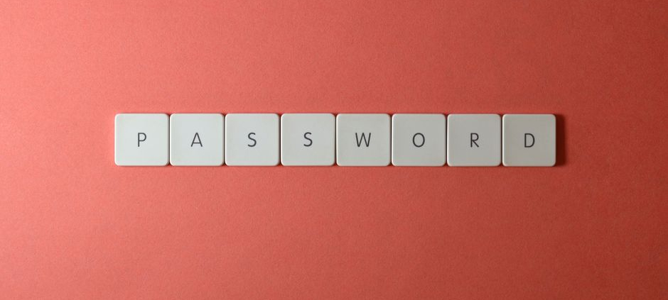 Focus on password security with white keyboard tiles spelling 'PASSWORD' on a coral background.